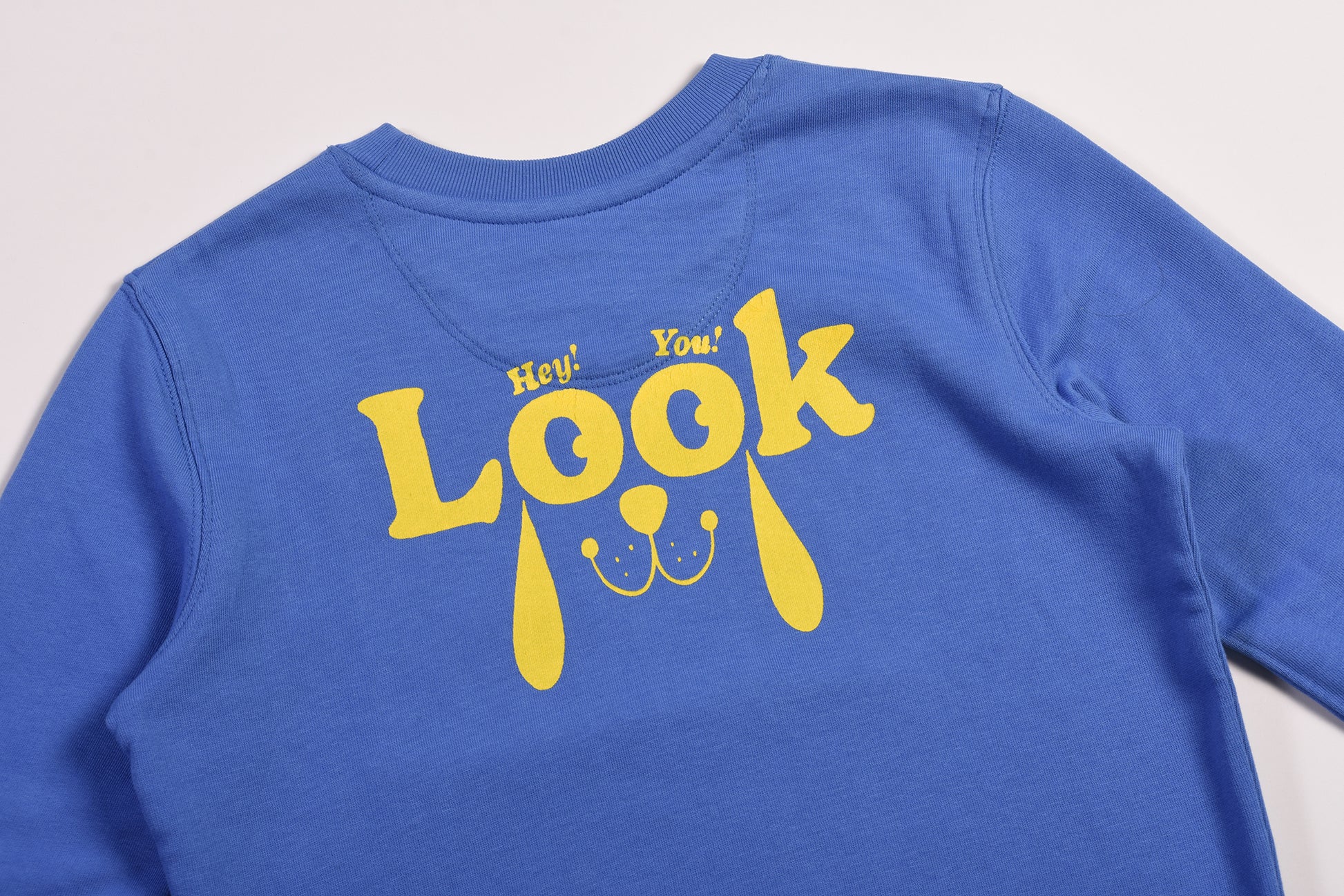 Blue sweatshirt with yellow text and graphics on a light gray background