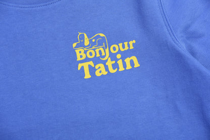 Blue shirt with 'Bonjour Tatin' text in yellow on a close-up view