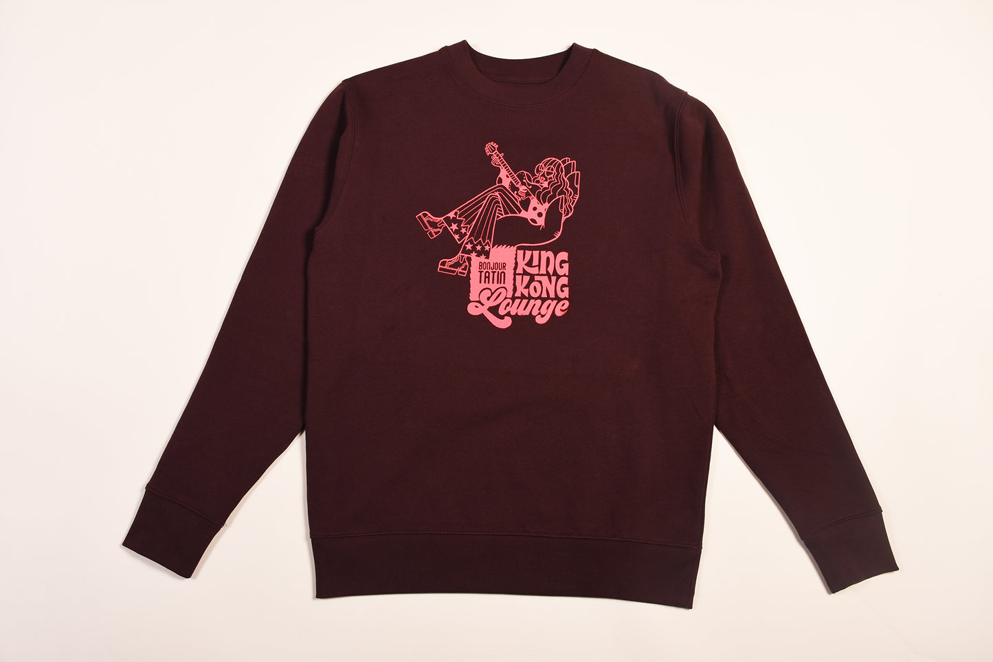  a long-sleeved burgundy red sweater with a graphic print of King Kong on a white background