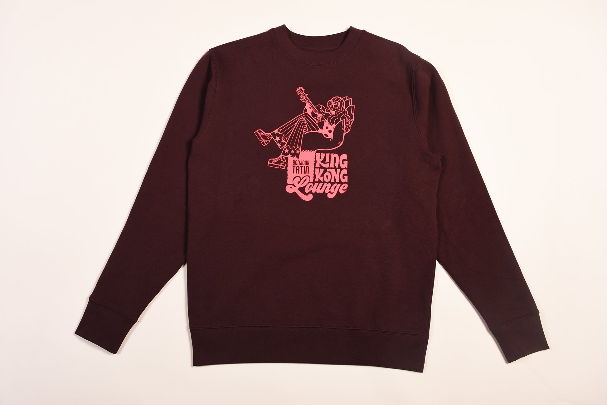  a long-sleeved burgundy red sweater with a graphic print of King Kong on a white background