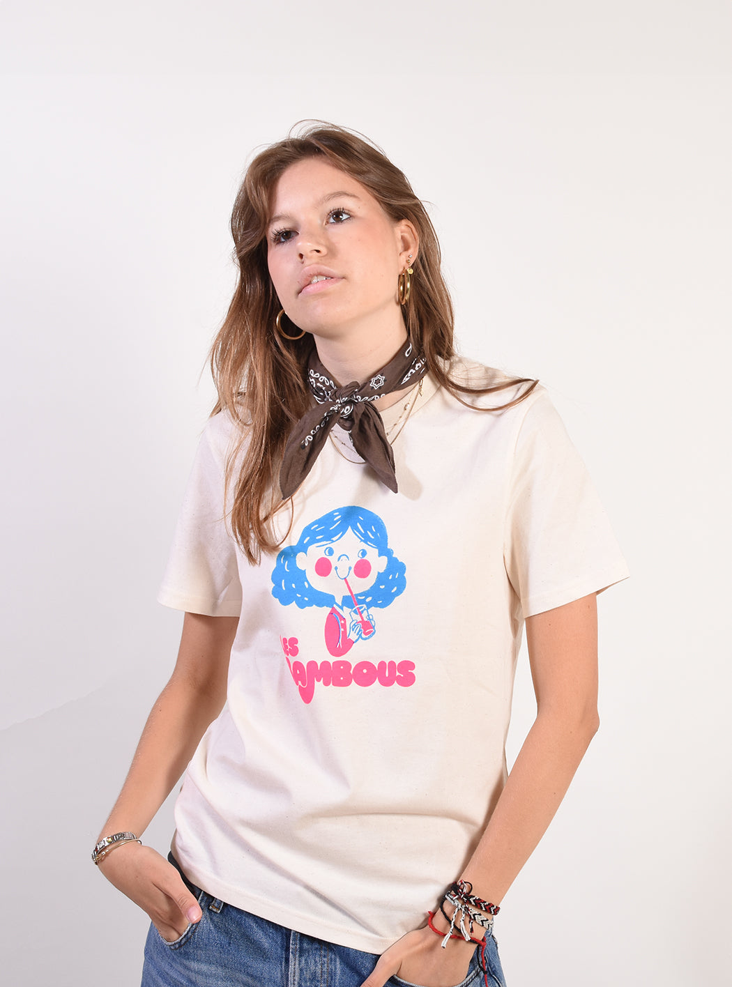 Person wearing a white t-shirt with a colorful graphic design on a plain background