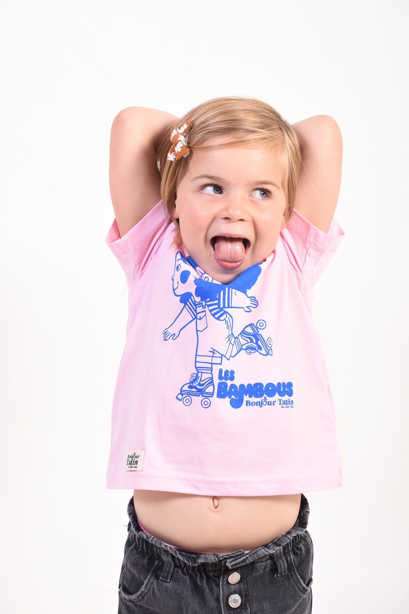 Child wearing a pink t-shirt with a graphic design on a white background