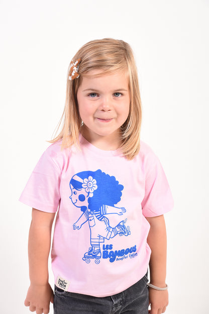 Young girl wearing a pink t-shirt with a blue graphic design on a white background