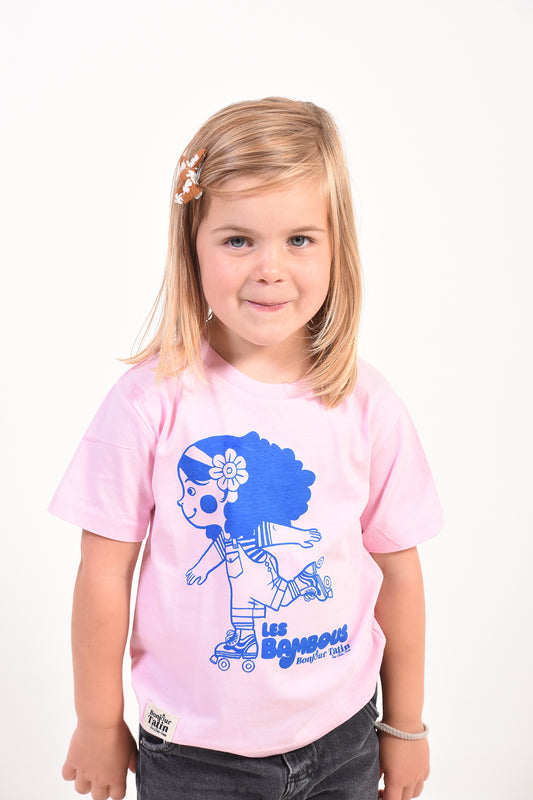 Young girl wearing a pink t-shirt with a blue graphic design on a white background